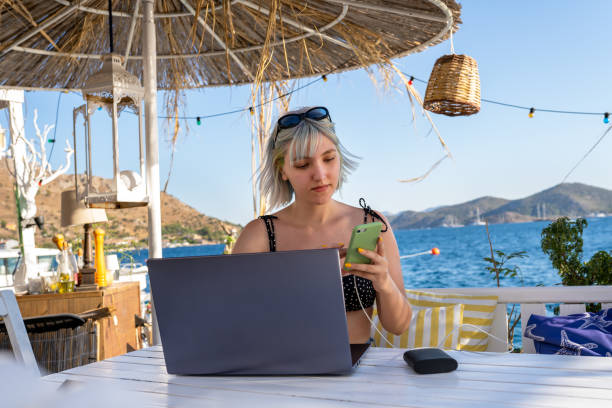 istock Young woman working on her vacation and using phone 1327147306