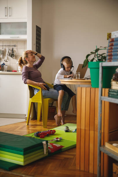 little mischievous boy making a mess while his mother is working from home - inconvenience meeting business distracted imagens e fotografias de stock