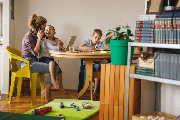 woman trying to have a phone call, getting interrupted by her son - inconvenience meeting business distracted imagens e fotografias de stock