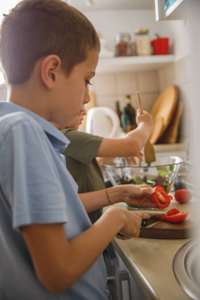 istock Two little boys preparing vegetables for a healthy salad they are making 1327148700