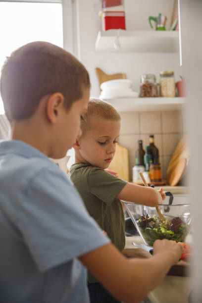 istock Two little boys preparing a salad together 1327148710