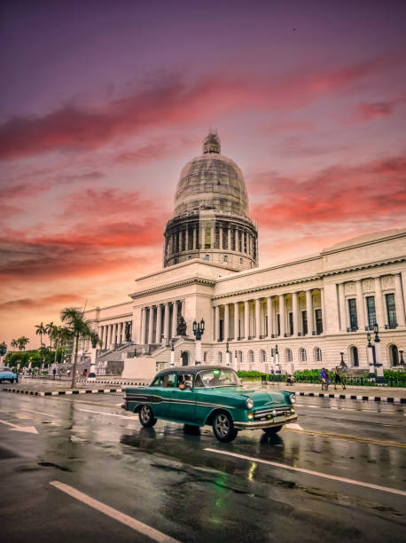 zielony vintage samochód porusza się przed el capitolio o zachodzie słońca, hawana, kuba - cuba cuban culture car collectors car zdjęcia i obrazy z banku zdjęć