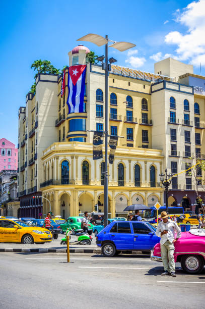 Street in Havana, Cuba with coloured vintage american car July 31, 2018 - La Havana, Cuba: taxi driver and vintage cars in Old Havana streets, Cuba old havana stock pictures, royalty-free photos & images