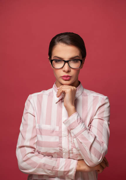 istock Smart confident woman in glasses on red background 1327152381