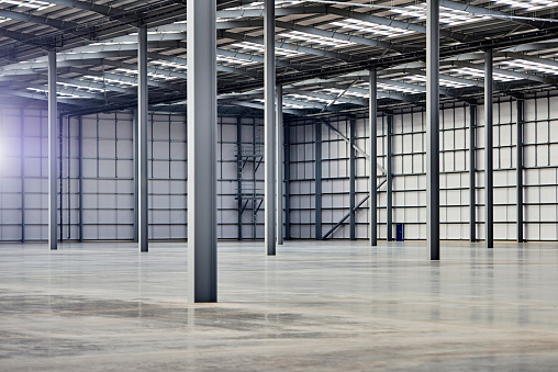Empty factory or warehouse building with concrete floor for industry background