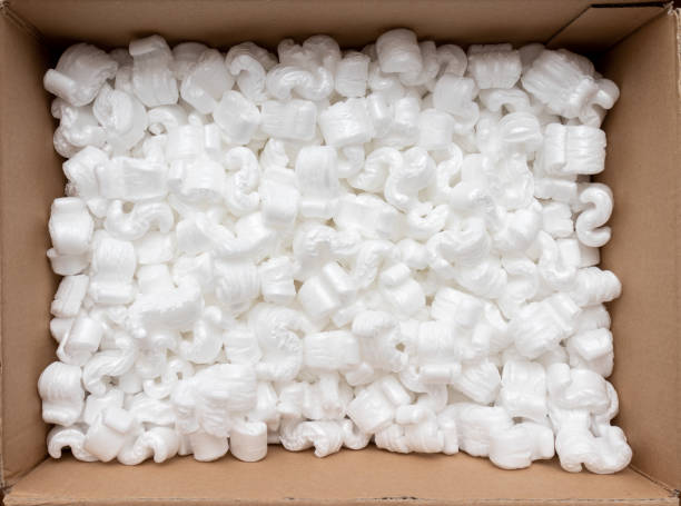 A cardboard box with packing styro foam pellets top view A cardboard box filled with packing styro foam pellets to pack fragile shipments top view. Packaging or online shopping ordering concept. polystyrene box stock pictures, royalty-free photos & images