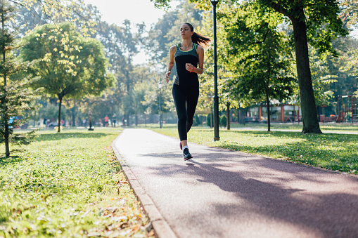 Woman running on jogging path in the park.