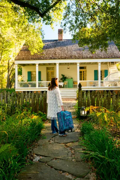 Female guest arrives to stay at Maison Madeleine, a restored 1840'2 French Creole cottage on the edge of Lake Martin swamp, Lafayette, Breaux Bridge, Louisiana