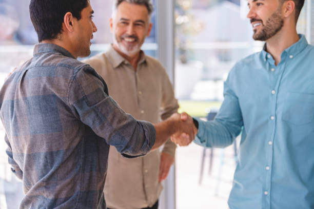 istock Three businessmen meeting, two are shaking hands. 1327161163