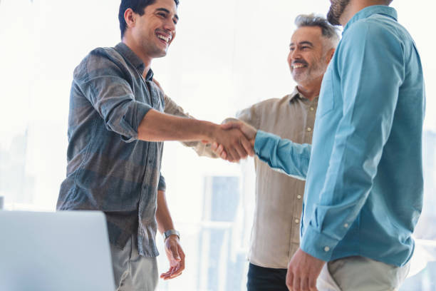 istock Three businessmen meeting, two are shaking hands. 1327161168