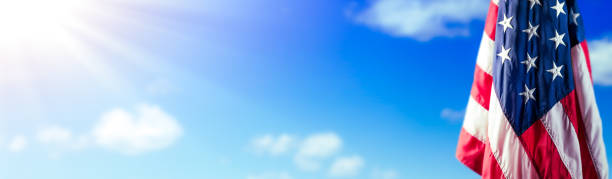 istock American Flag With Blue Sky And Sunlight 1327161853