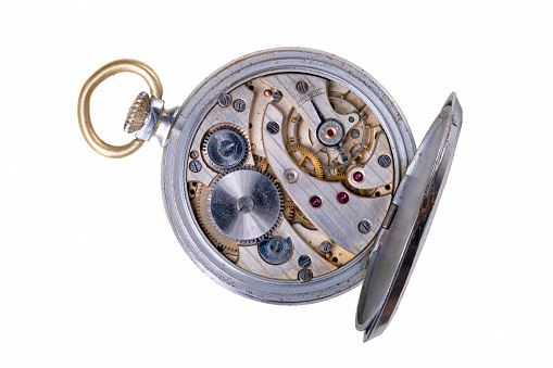 The inside of a spring-powered watch. Mechanism and gears in a portable timing device. Isolated background.