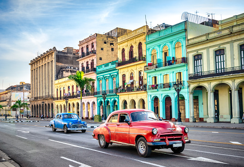 two vintage taxi cars in front of historic buildings in Old Havana, Cuba