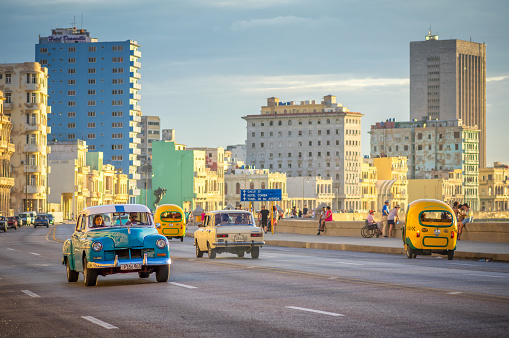 August 1, 2018 - Havana, Cuba: Vintage cars driving along Malecon, Havana as sun goes down