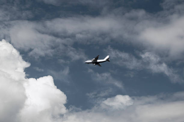 istock Aerial concept on a blue sky among white clouds and sunlight a passenger or cargo plane is flying 1327165575