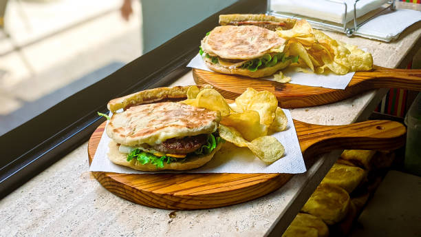 sanduíches portugueses com batatas fritas para o almoço servido em uma raquete de madeira - gastronomia de portugal - fotografias e filmes do acervo