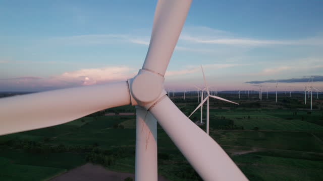 sunset at wind turbine power generator farm.
