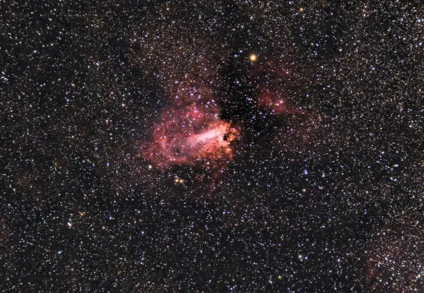 The Omega Nebula, also known as the Swan Nebula, Checkmark Nebula, and Horseshoe Nebula Messier 17, M17, captured with a refracting telescope and a cooled astronomical camera