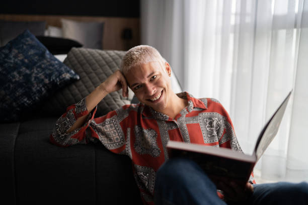 portret szczęśliwego młodego mężczyzny czytającego w domu - sitting young men book isolated on white zdjęcia i obrazy z banku zdjęć