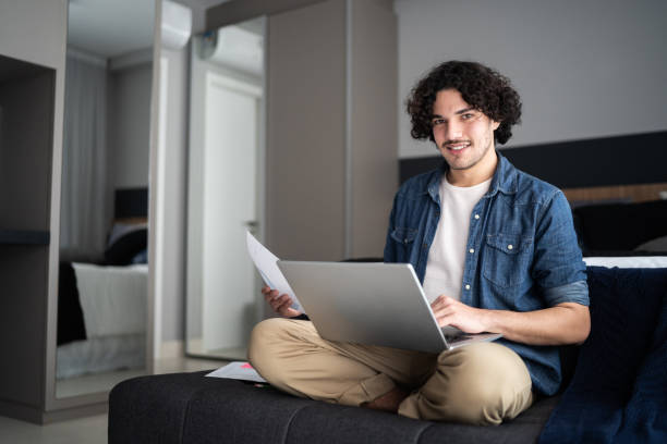 istock Portrait of a young man using laptop working at home 1327181069