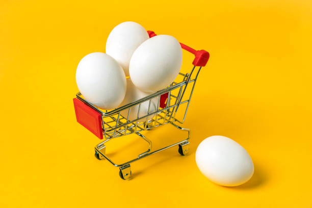 istock Shopping cart full of white eggs on yellow backgdrop 1327181072