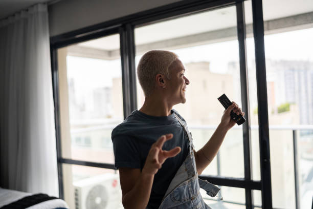 istock Excited young man singing and dancing at home 1327181715