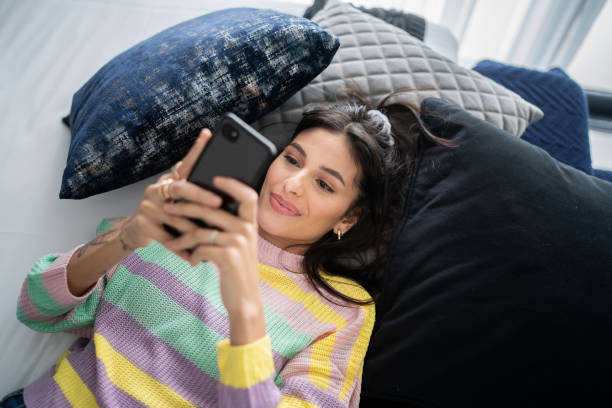 istock Young woman using smartphone at home 1327181844