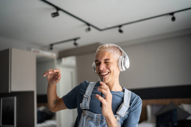 istock Young man singing and dancing at home 1327182395