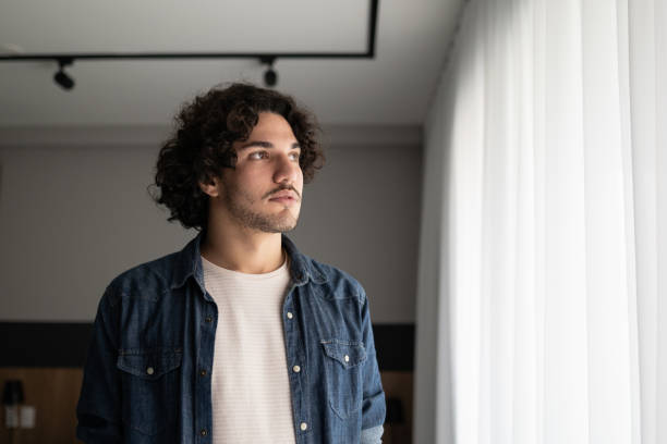 istock Young man contemplating at home 1327183746