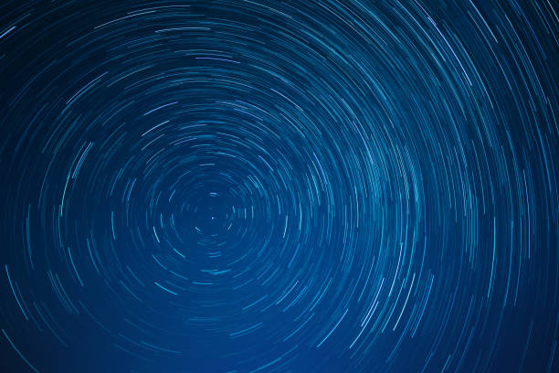 Low angle view of star trails against sky