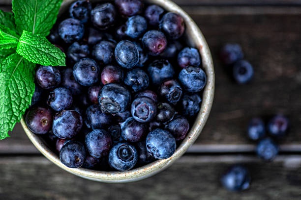 istock Blackberries in a Ceramic Bowl on Wood Background 1327188353