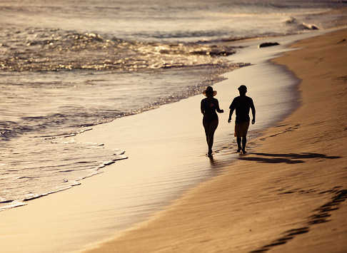 Hispanic woman and her son walking in a deserted beach
