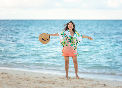 Hispanic mature woman enjoying the beach in Hawaii