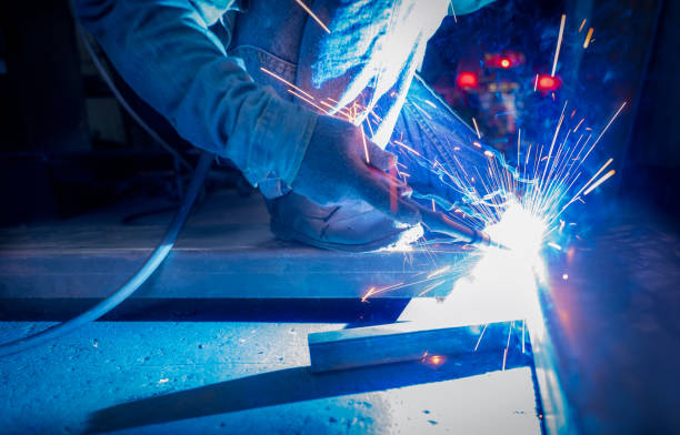 istock Welder welding metal with argon arc welding machine and has welding sparks. A man wears protective gloves. Safety in industrial workplace. Welder working with safety. Worker in steel industry factory. 1327190366