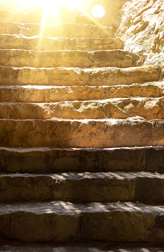 ancient steps on the stairs in Israel. Sunlight shines from above the frame