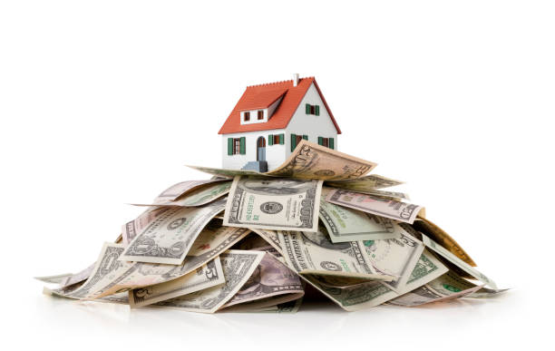 istock Miniature model house standing on a heap of dollar bills 1327200773