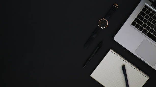 istock Top view of work desk on black background 1327203317
