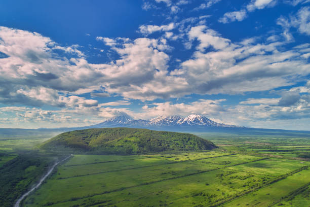 Flight over the fields on Kamchatka with a view of home volcanoes