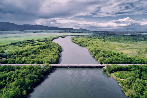 The bridge over the river is shot from the drone. Kamchatka, Avacha river.
