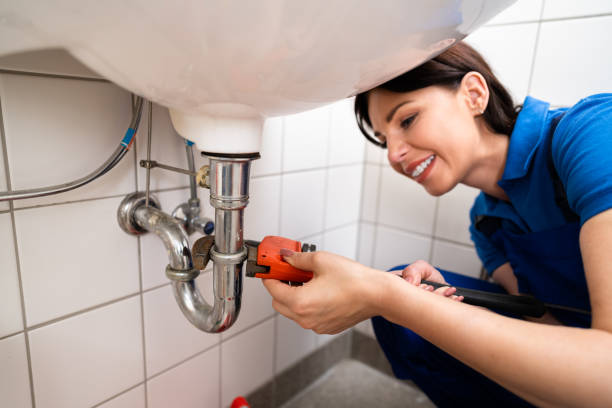 Plumber Fixing A Sink In Bathroom