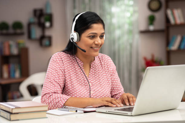 Happy business women and teacher with headphones using laptop for video call:- stock photo Adult, Adults Only, Advice, India, Indian ethnicity, teacher, business women Online Course stock pictures, royalty-free photos & images