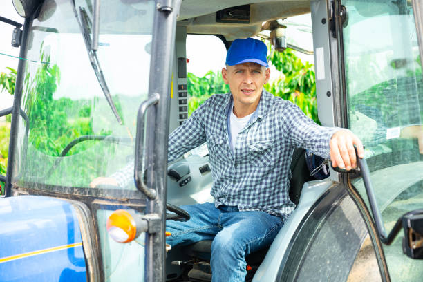 istock Skilled male farmer working on farm tractor in orchard 1327208308