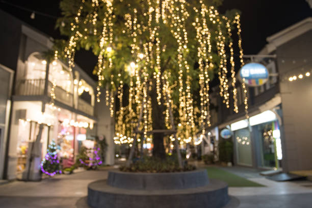 Blurred image Decorative outdoor string lights hanging on tree in the garden at night time