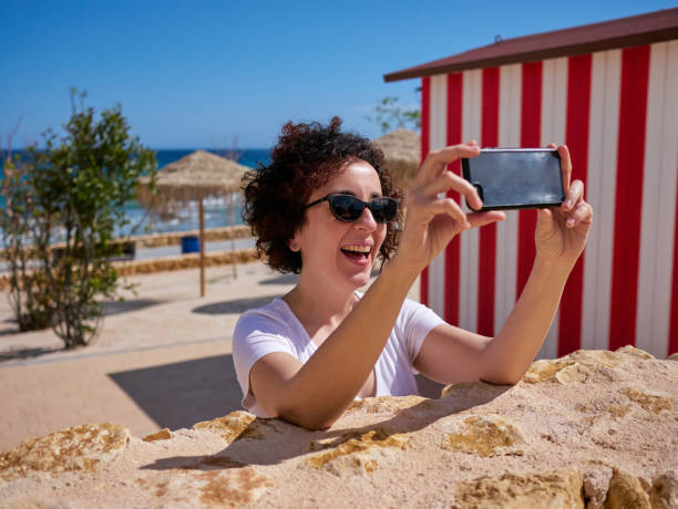 istock Woman taking a selfie next to a beach hut 1327209886