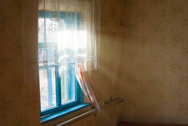 istock rays of sun pushing through a rural house window 1327211304