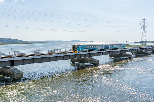 Passenger train crossing bridge over sea