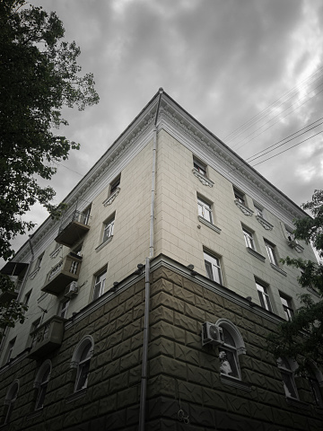Fragmento de la fachada clasicista de la casa en un día nublado. Casa en el estilo del Imperio estalinista, vista de abajo hacia arriba. photo