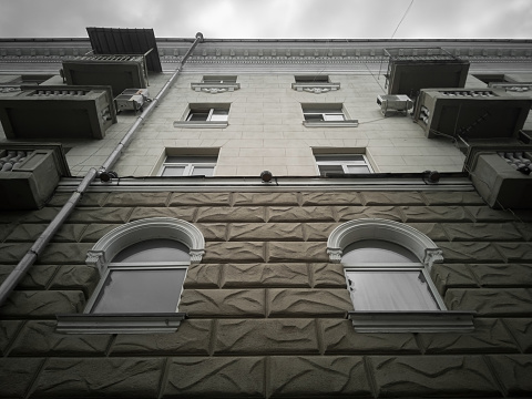 Fragmento de la fachada clasicista de la casa en un día nublado. Casa en el estilo del Imperio estalinista, vista de abajo hacia arriba. photo