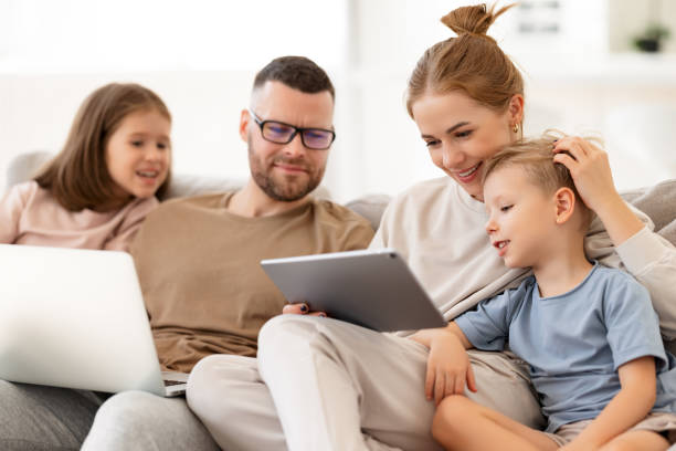 istock Young family addicted with gadgets relaxing on sofa at home 1327216997