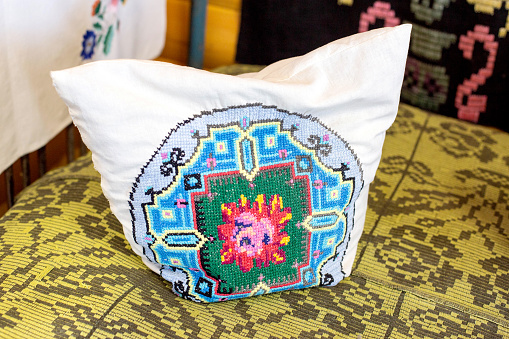 Rustic pillow with an embroidered pattern and ornament, traditional, close-up. Geometrical